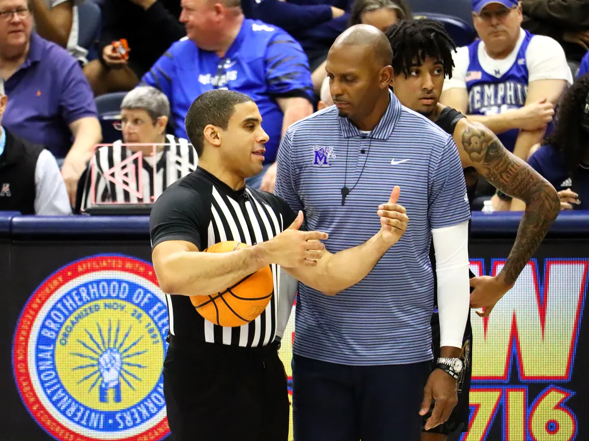 Penny Hardaway, in a Memphis Tigers polo, talks with a referee on the sideline during Memphis at Rice in February 2025
